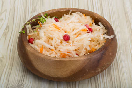 Sauerkraut with berries in the bowl on wooden backgroundの写真素材