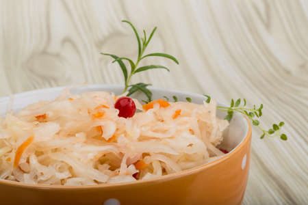 Sauerkraut with berries in the bowl on wooden backgroundの写真素材