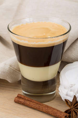 Capuccino with zephyr and cinnamon on the wooden background