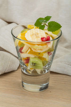 Fruit salad with banana, orange, kiwi and grapeの写真素材