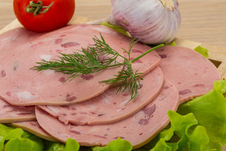 Beef sausage sliced with salad and garlik