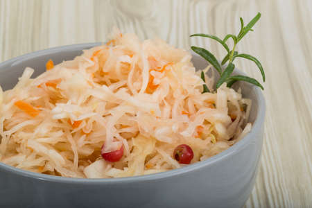 Sauerkraut with berries in the bowl on wooden backgroundの写真素材