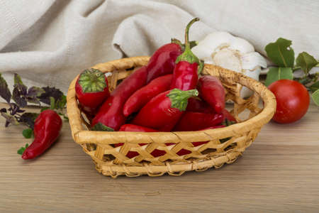 Chili peppers in the bowl on wooden backgroundの写真素材