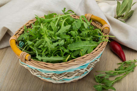 Ruccola leaves mix in the bowl on wooden backgroundの写真素材