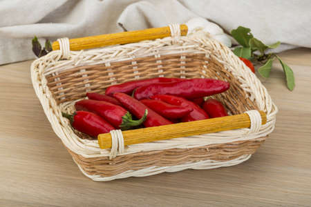 Chili peppers in the bowl on wooden backgroundの写真素材