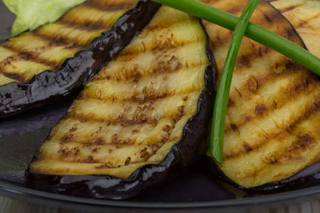 Grilled eggplants in the plate on wooden backgroundの写真素材