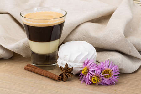 Capuccino with zephyr and cinnamon on the wooden backgroundの写真素材