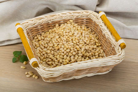 Cedar nut in the bowl on wooden backgroundの写真素材