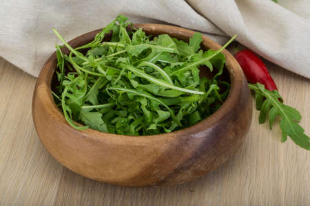 Ruccola leaves mix in the bowl on wooden backgroundの写真素材