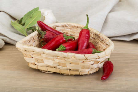 Chili peppers in the bowl on wooden backgroundの写真素材