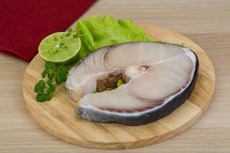 Raw blue shark steak with salad leaves and lime