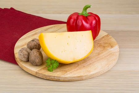 Yellow round cheese on the wood 