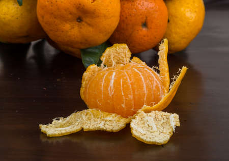 Tangerines with leaves in heap on wood background