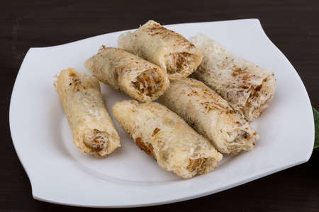 Vietnamese Spring rolls with spicy sauce on wood background