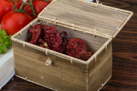Dried tomtoes in the bowl on wooden backgroundの写真素材
