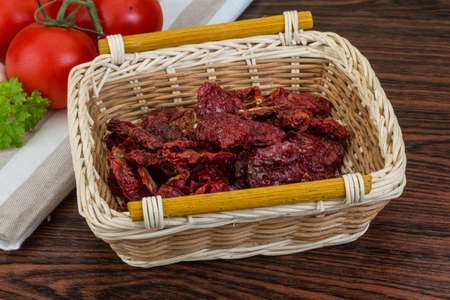 Dried tomtoes in the bowl on wooden backgroundの写真素材