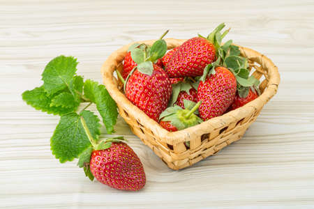Fresh ripe strawberries in the bowl on wooden backgroundの写真素材