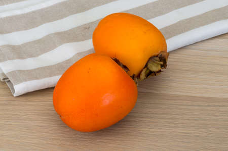 Fresh ripe Persimmon on the wooden backgroundの写真素材