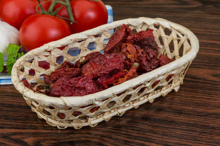 Dried tomtoes in the bowl on wooden backgroundの写真素材