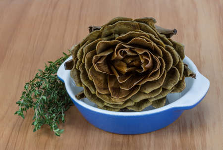 Boiled artichokes with thyme on the wooden backgroundの写真素材