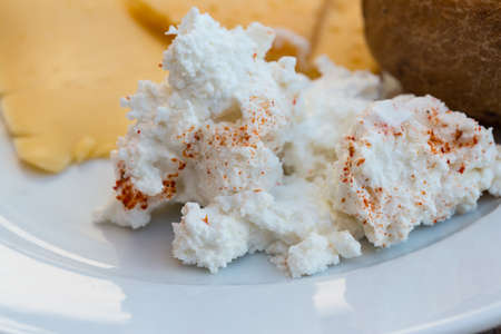 Ricotta and yellow cheeses with bun on breakfastの写真素材