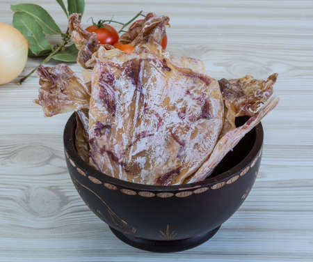Dried squids in the bowl with spices on wood の写真素材