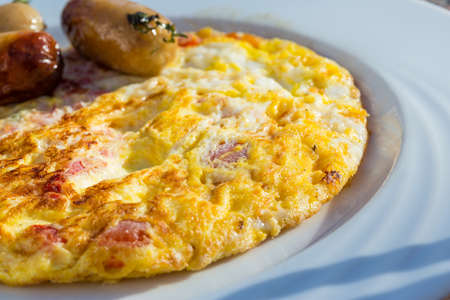 Omelet with sausages, yellow cheese and tomatoの写真素材