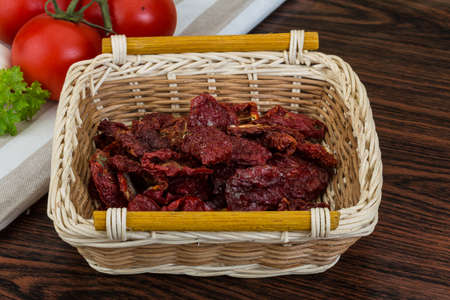 Dried tomtoes in the bowl on wooden backgroundの写真素材