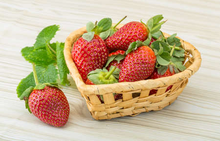 Fresh ripe strawberries in the bowl on wooden backgroundの写真素材