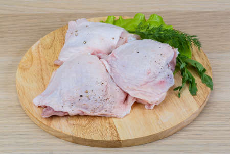 Raw chicken thighs with salad leaves and ruccolaの写真素材