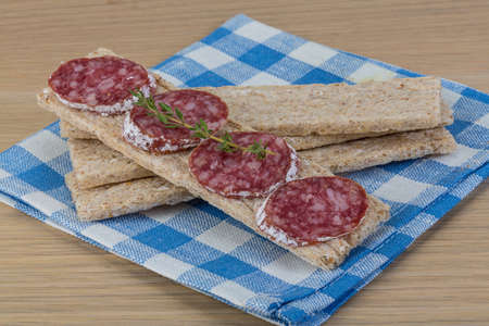 Crispbread with salami and fresh rucola leavesの写真素材