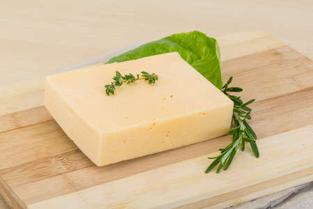 Yellow cheese brick with rosemary and thyme