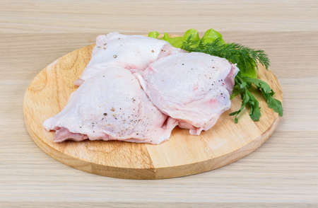 Raw chicken thighs with salad leaves and ruccolaの写真素材