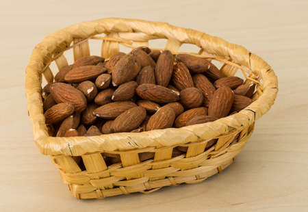 Roasted Almonds in the bowl on wood backgroundの写真素材