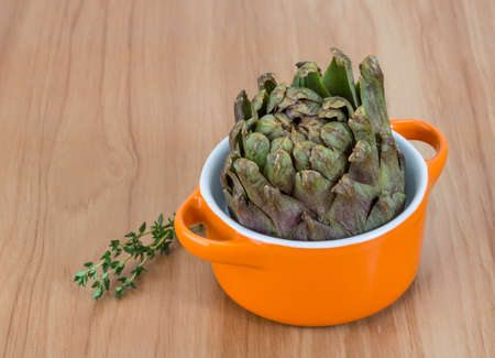 Fresh Raw artichokes on the wooden backgroundの写真素材