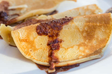 Pancakes with chocolate syrupe in the plateの写真素材