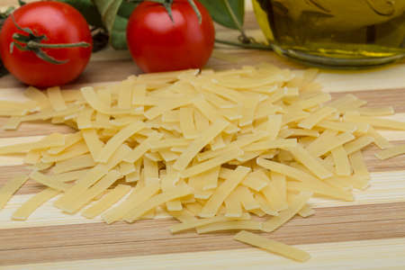 Raw Italian pasta on the wood background