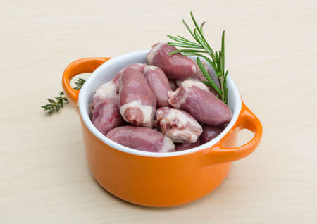 Raw chicken hearts with thyme and rosemary - ready for cookingの写真素材