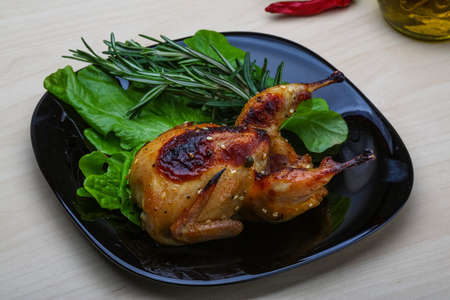 Roasted Quail with rosemary and spices on the wood backgroundの写真素材