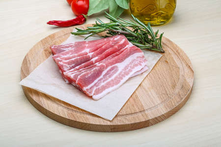 Sliced bacon with rosemary on the wood backgroundの写真素材