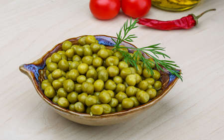 Green canned peas in the bowl on the wood backgroundの写真素材