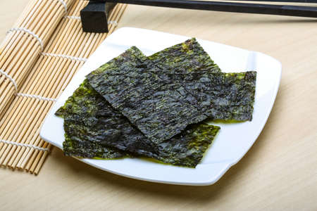Nori sheets with sticks on the wood backgroundの写真素材