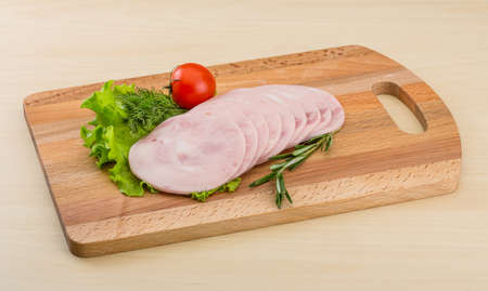 Sliced Ham with rosemary on the wooden bckgroundの写真素材