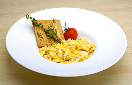 Scrambled eggs with tomato, dill and black oliveの写真素材