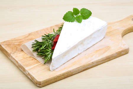 Soft brie cheese with rosemary, thyme on the wood backgroundの写真素材
