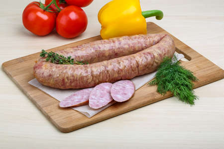 Smoked sausages with dill on the wood background
