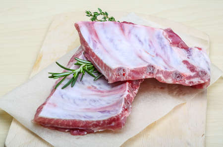 Raw pork ribs with rosemary and thymeの写真素材