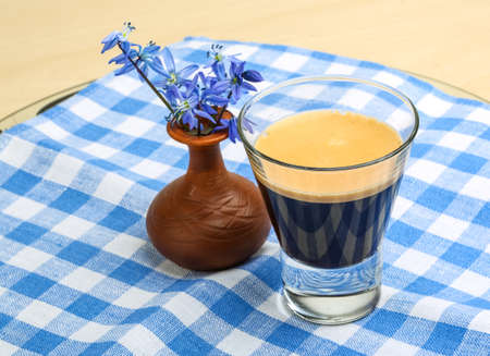 Hot Espresso coffee with blue spring flowersの写真素材