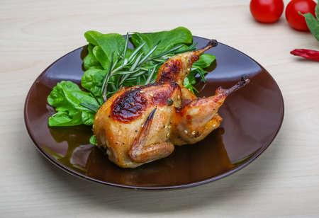 Roasted Quail with rosemary and spices on the wood backgroundの写真素材
