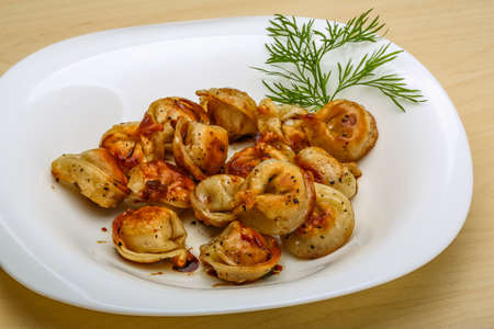 Fried russian dumplings with dill on woodの写真素材